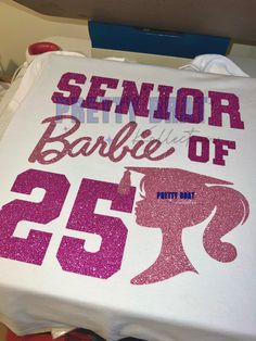 a white t - shirt with pink glitter on it that says senior barbie of 25