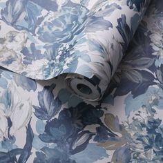 a blue and white floral wallpaper with large flowers on the back, along with a roll of tape