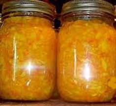 two jars filled with yellow liquid sitting on top of a shelf