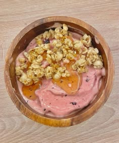 a wooden bowl filled with fruit and nuts