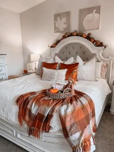 a white bed topped with pillows and blankets