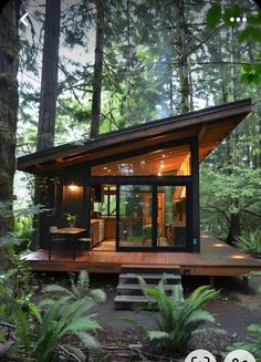 a small cabin in the middle of a forest with stairs leading up to it's entrance