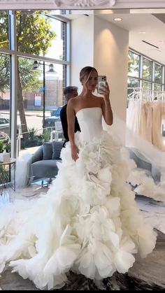 a woman taking a selfie in a wedding dress made out of ruffles