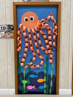 an octopus made out of construction paper and some orange tape is hanging on the door