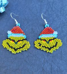 a pair of beaded earrings with an image of the grin face on each ear