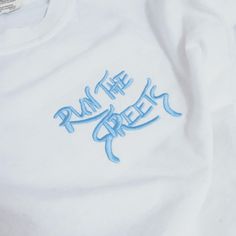 "Show your love for the streetwear culture with our 'Run the Streets' embroidered graphic on your choice from t-shirt or hoodie. Embroidery is done in-house, customize by choosing any embroidery thread color (chart in photos). Made with sustainably and fairly grown USA cotton. Direct embroidery, only available here at Run The Streets Shop!🔥 * 4\" embroidered graphic. * T-shirts are 100% cotton. * Hoodies are 80% cotton/20% polyester. * True to size, classic fit. (measurements in photos) * Free Custom Embroidered Cotton T-shirt For Streetwear, Custom Embroidered Tops For Streetwear, Cotton Sweatshirt With Embroidered Logo For Streetwear, Sporty Custom Embroidered Tops For Streetwear, Urban Tops With Embroidered Logo For Streetwear, Embroidered Relaxed Fit T-shirt For Streetwear, Sporty Embroidered Top For Streetwear, Embroidered Cotton Tops For Streetwear, Fan Apparel Cotton Sweatshirt With Embroidered Graphics