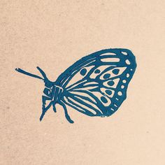 a blue butterfly sitting on top of a piece of paper