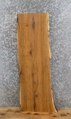 a piece of wood sitting on top of a wooden table next to a gray wall