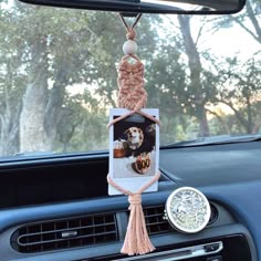 a car dashboard with a photo hanging from it's dash board and a tassel