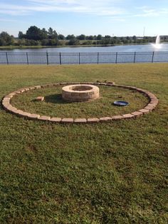 a fire pit in the middle of a grassy field