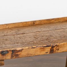 an old wooden bench sitting on top of a hard wood floor