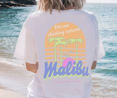 Stay cool this summer with our Y2K inspired Forever Chasing Sunsets Malibu '00 Summer Fest Comfort Colors shirt!   Graphic is distressed for a vintage look. This is a unisex shirt.  Please double check the size charts and order your size accordingly. Refunds are not given for ordering the wrong size.  Size up a couple sizes for an oversized look. *The larger the shirt, the larger the graphic.  Our printer sizes the graphics proportionate to the size of the shirt.   **Please understand that due t Miami Beach Tshirt, White Graphic Print Shirt For Beach Party, White Custom Print Shirt For Summer, Summer Short Sleeve Shirt With Front Print, White Shirt With Front Print For Summer, Graphic Print Shirt For Beach Party In Summer, Graphic Print Shirt For Beach Party, Graphic Print Shirt For Summer Beach Party, Beach Shirt With Sublimation Print