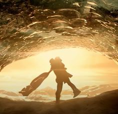 a man and woman holding each other while standing in a tunnel with sunlight coming through