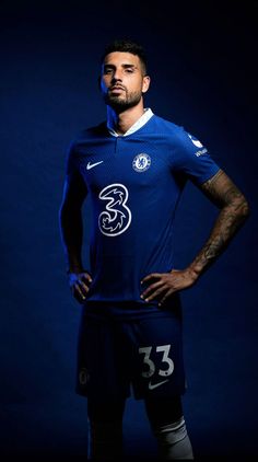 a man in a blue soccer uniform is posing for a photo with his hands on his hips