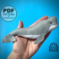 a hand holding a stuffed dolphin toy in front of a blue background with the words pattern and instructions below it