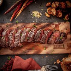 the steak is ready to be cooked on the cutting board with other food items around it