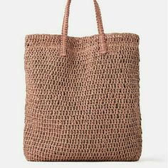 a crocheted bag is shown on a white background and it has a brown handle