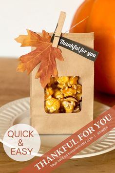 a paper bag filled with nuts sitting on top of a plate next to an orange