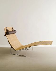 a lounge chair sitting on top of a white floor next to a wall in an empty room