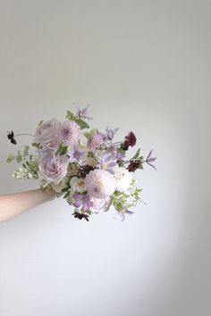 a woman holding a bouquet of flowers in her hand