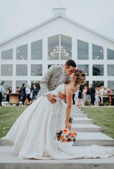 a bride and groom kissing on the steps