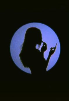 the silhouette of a woman holding a cell phone to her ear