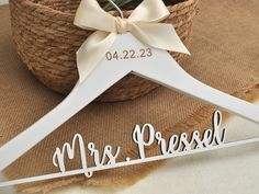 a white wooden hanger with a bow on it that says mr and mrs pressed