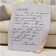 an old handwritten note on a sheet of paper with writing underneath it, in front of a white couch