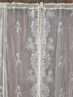 an open curtain with white lace on it