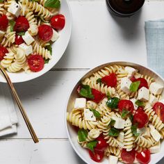 two plates of pasta with tomatoes, mozzarella and basil