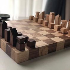 a wooden chess board sitting on top of a table