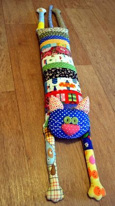 a multicolored stuffed animal laying on top of a wooden floor