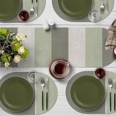 the table is set with green plates and silverware