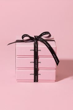 a stack of pink boxes wrapped in black ribbon