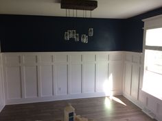 empty room with blue walls and white wainscothes on the wall, wood flooring