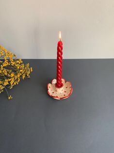 a red candle sitting on top of a table