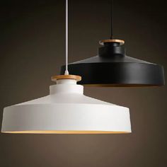 two black and white lights hanging from a ceiling fixture with one light on the other side