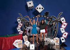 two women standing in front of a display of playing cards and dices with palm trees