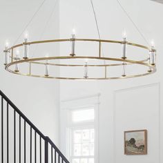 a chandelier hanging from the ceiling in a living room next to a stair case