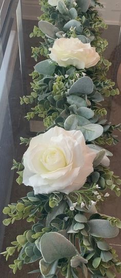 some white flowers and green leaves on a table