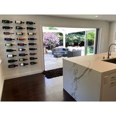 a kitchen with an island and wine racks on the wall in front of glass doors