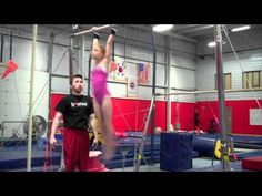 a man standing on top of a pole in a gym