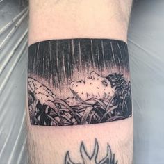 a man's arm with a black and white drawing of a cat in the rain