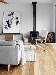 a living room filled with furniture and a wood burning stove in the middle of it