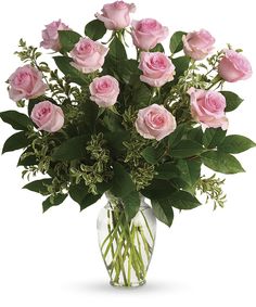 a vase filled with pink roses and greenery