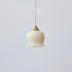 a white light hanging from a gold chain