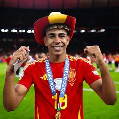 a young man wearing a red hat and holding a silver medal