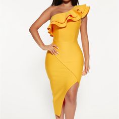 a woman wearing a yellow dress with ruffles on the shoulders and one leg