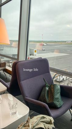 an airport lounge chair next to a large window