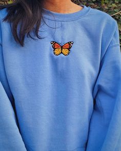 This Carolina blue crewneck is embroidered with an orange and yellow Monarch butterfly. Whether it's for yourself or a gift, get cozy, comfy, and stylish with this embroidered sweatshirt. Crewnecks are embroidered with a one-of-a-kind design inspired by places, experiences, and adventures! ⭐  PRODUCT DETAILS * Unisex Sizing * Sweatshirts: 50% cotton, 50% polyester * T-Shirts: 100% cotton * Size up 1-2 sizes for a looser comfy fit ⭐  CARE INSTRUCTIONS Wash with cold water. Hang drying is recommen Blue Hoodie Embroidery, Blue Crew Neck Hoodie With Embroidered Graphics, Blue Embroidered Crew Neck Hoodie, Orange Casual Crew Neck Hoodie, Casual Orange Crew Neck Hoodie, Casual Sweatshirt With Custom Embroidery Relaxed Fit, Casual Relaxed Fit Sweatshirt With Custom Embroidery, Blue Sweatshirt For Spring, Comfortable Blue Sweatshirt For Spring